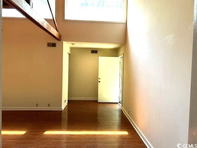 hallway featuring dark hardwood / wood-style flooring and a high ceiling