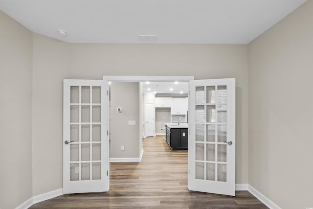 spare room with hardwood / wood-style flooring and french doors