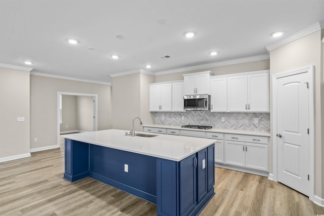 kitchen featuring white cabinets, appliances with stainless steel finishes, an island with sink, and sink