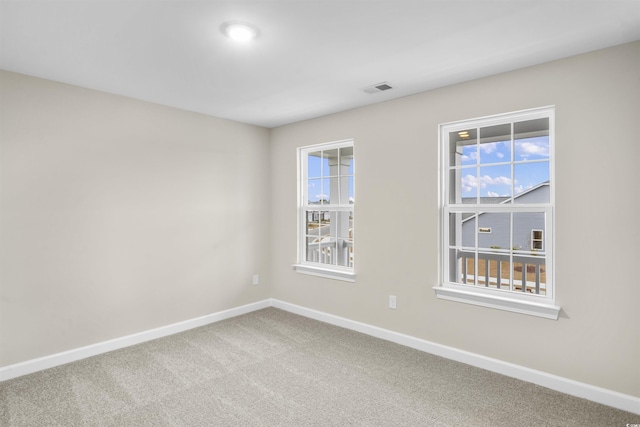 empty room with a healthy amount of sunlight and carpet floors