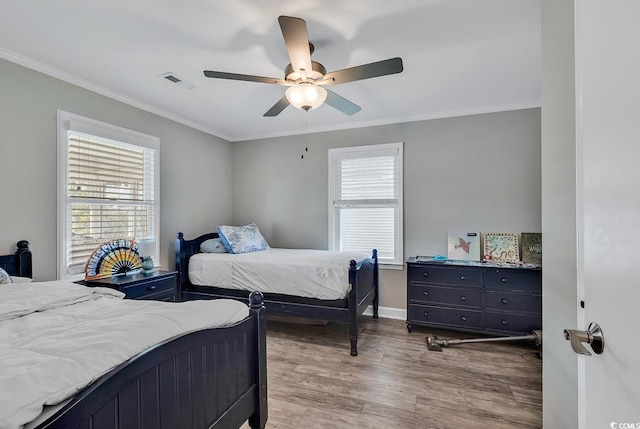 bedroom featuring hardwood / wood-style floors, ornamental molding, and ceiling fan