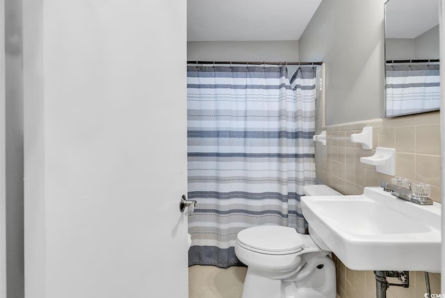 bathroom with tile walls, sink, backsplash, and toilet