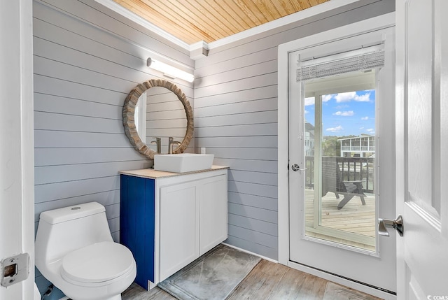 bathroom featuring ornamental molding, wooden ceiling, wood-type flooring, vanity, and toilet