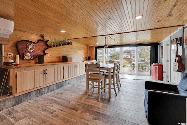 dining area with wooden ceiling, hardwood / wood-style flooring, wooden walls, and a wall mounted air conditioner