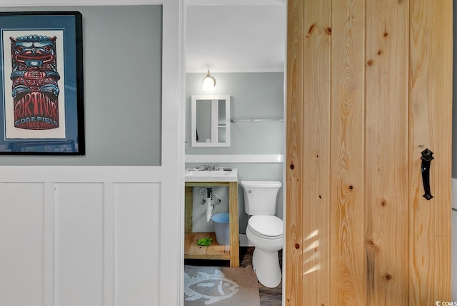 bathroom with sink, crown molding, and toilet