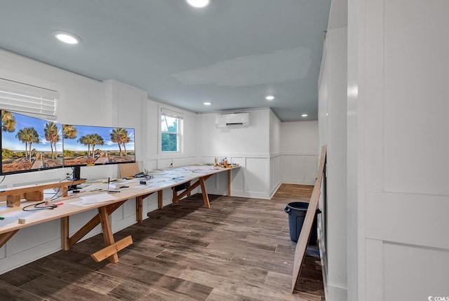 interior space with a wall mounted air conditioner and wood-type flooring