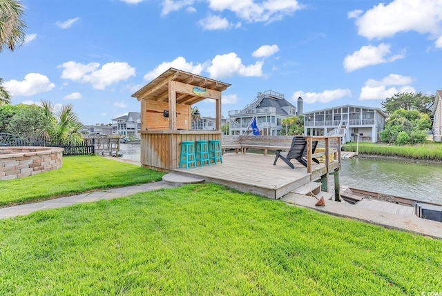 dock area with a lawn and a water view