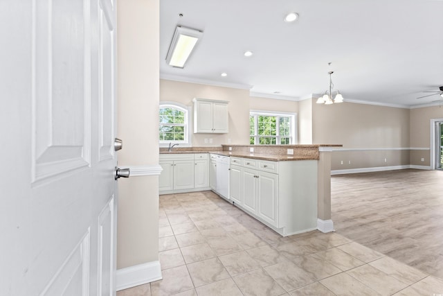 kitchen featuring white cabinets, ornamental molding, ceiling fan with notable chandelier, and kitchen peninsula