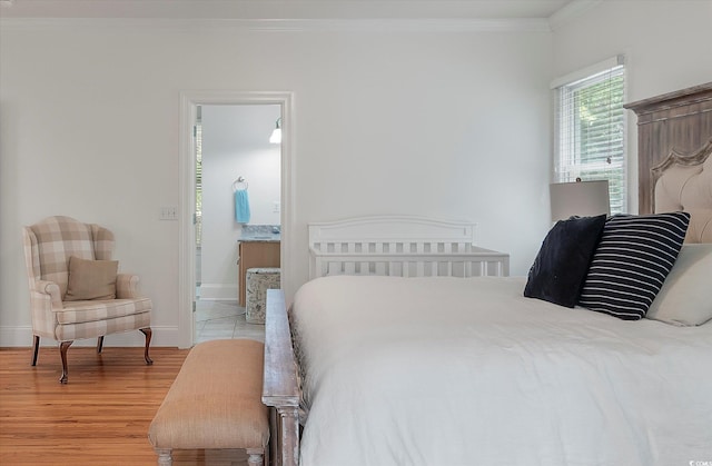 bedroom with ornamental molding and light wood-type flooring