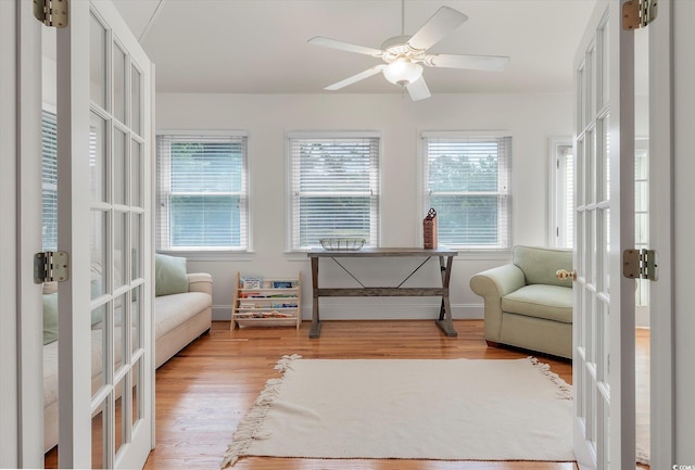 sitting room featuring wood-type flooring, french doors, and ceiling fan