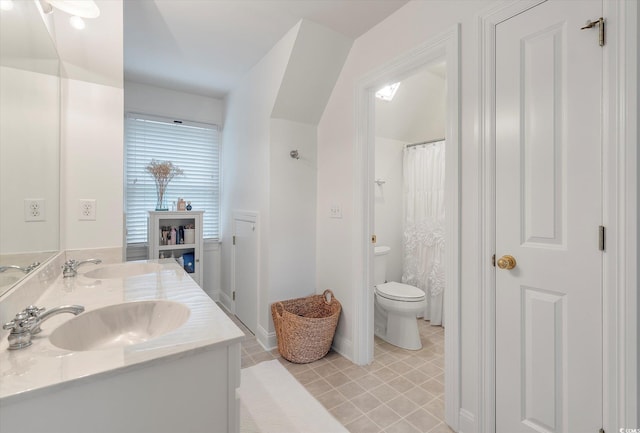 bathroom featuring double vanity, tile patterned flooring, and toilet