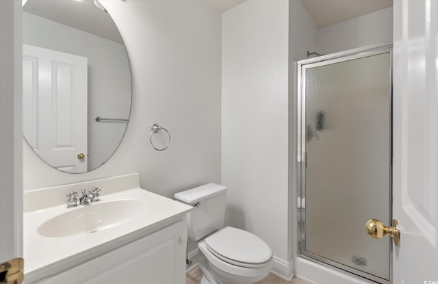 bathroom with a shower with shower door, vanity, tile patterned floors, and toilet