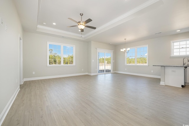 unfurnished living room with sink, a raised ceiling, light hardwood / wood-style floors, ceiling fan with notable chandelier, and ornamental molding