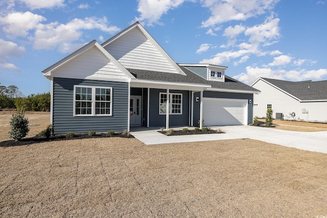 view of front of house with a garage, covered porch, and central AC