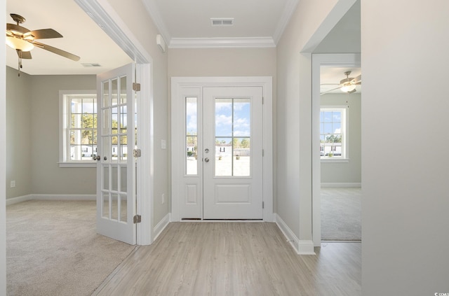 carpeted entrance foyer featuring ceiling fan and ornamental molding