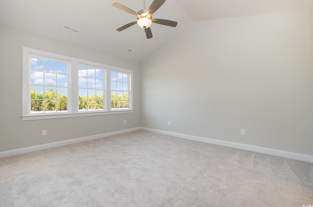 empty room with ceiling fan, light colored carpet, and vaulted ceiling