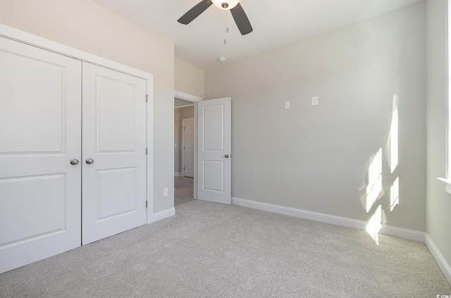 unfurnished bedroom featuring a closet, ceiling fan, and light colored carpet