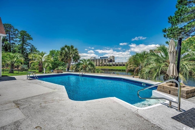 view of swimming pool with a patio area and a water view