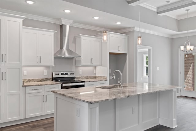 kitchen with decorative light fixtures, wall chimney range hood, stainless steel range with electric cooktop, and white cabinets