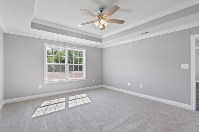 carpeted spare room featuring ceiling fan, a raised ceiling, and crown molding