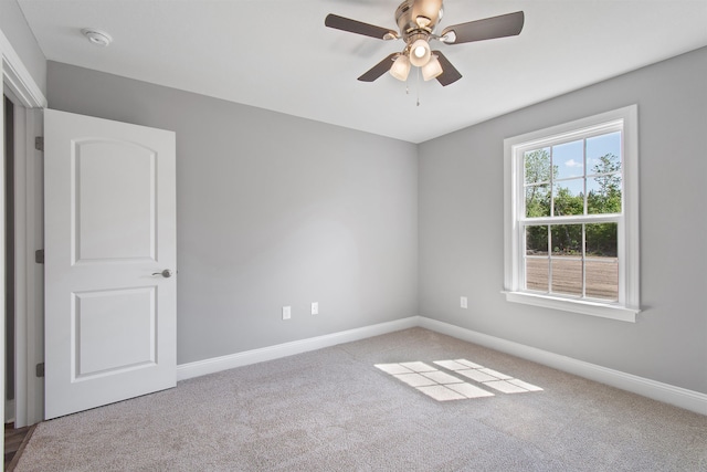 spare room with ceiling fan and light colored carpet