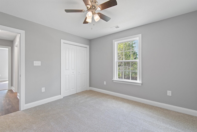 unfurnished bedroom with carpet, ceiling fan, and a closet