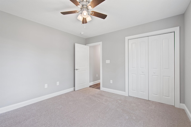 unfurnished bedroom with carpet flooring, ceiling fan, and a closet