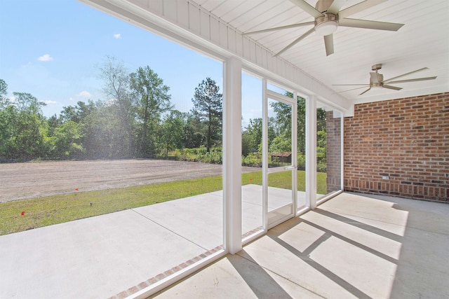 unfurnished sunroom with ceiling fan