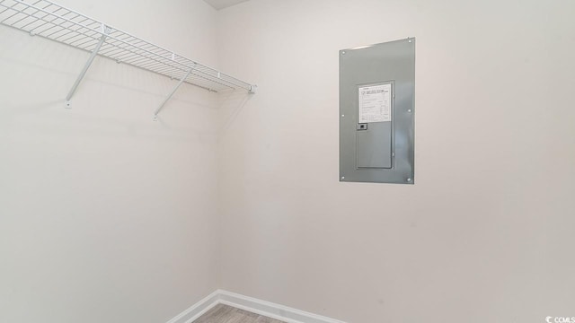 walk in closet featuring electric panel and wood finished floors