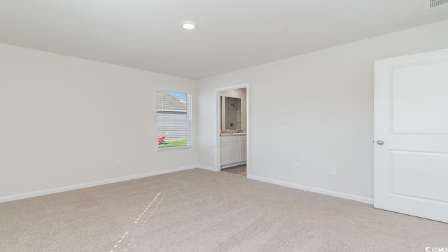 empty room featuring light colored carpet and baseboards