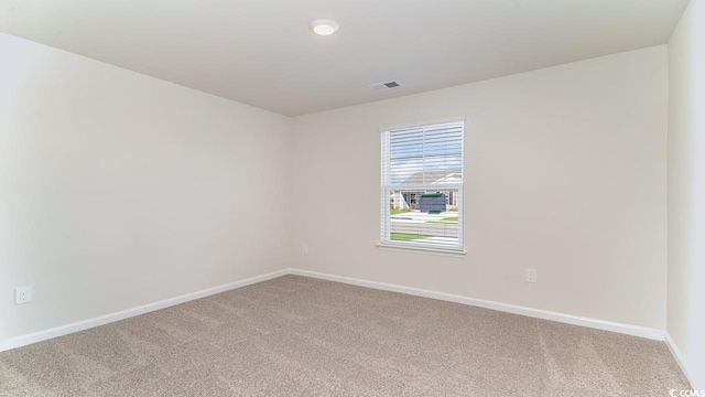 unfurnished room with visible vents, baseboards, and carpet flooring