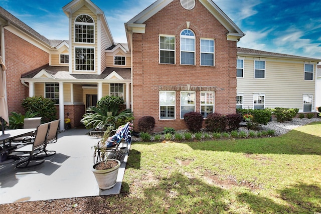 back of house with a yard and a patio