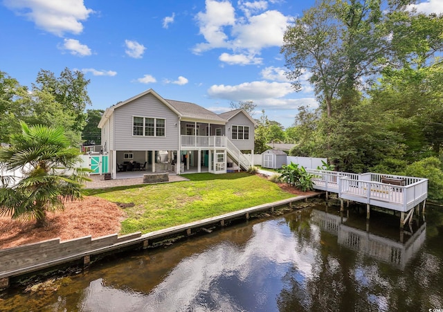 rear view of house with a yard, a patio area, and a swimming pool side deck with water view