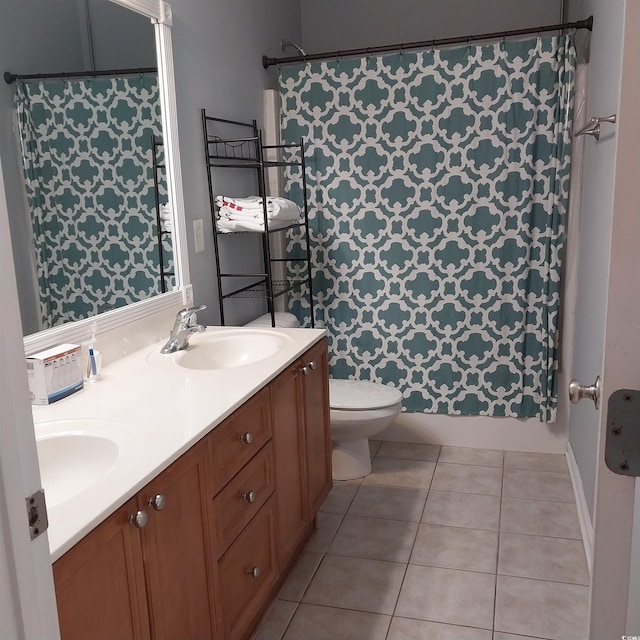 bathroom featuring tile flooring, dual vanity, and toilet