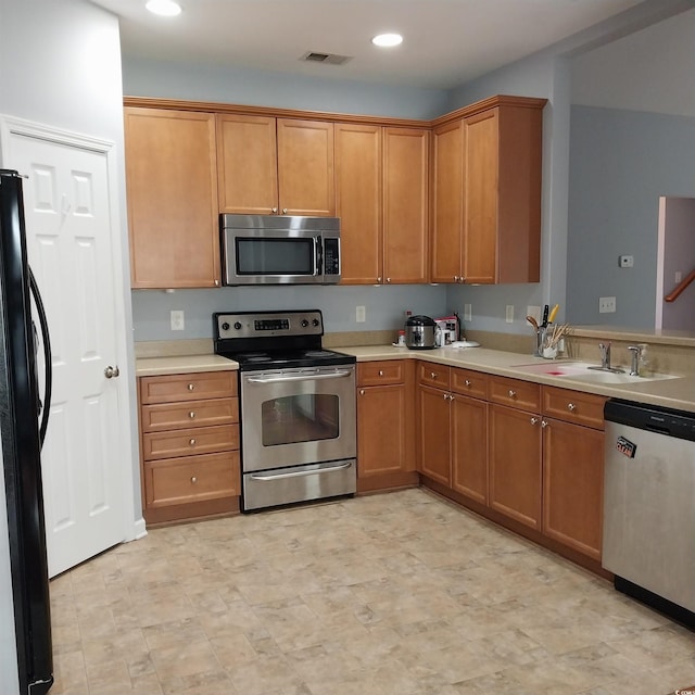 kitchen with sink, light tile floors, and appliances with stainless steel finishes