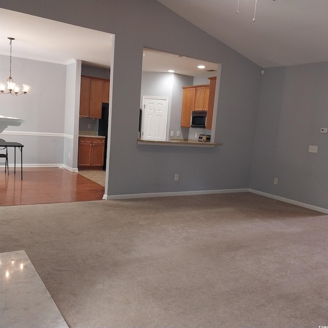 unfurnished living room featuring light carpet, lofted ceiling, and an inviting chandelier