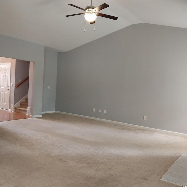 carpeted spare room with ceiling fan and vaulted ceiling