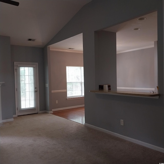 carpeted spare room featuring crown molding and lofted ceiling