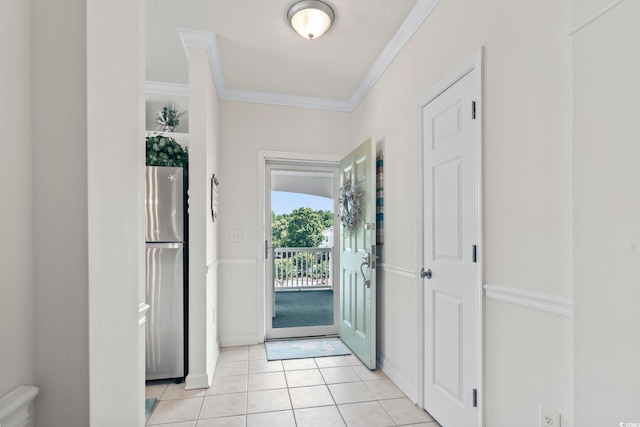 tiled entrance foyer featuring a textured ceiling and ornamental molding