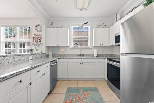 kitchen with white cabinets, sink, light tile patterned floors, and stainless steel appliances