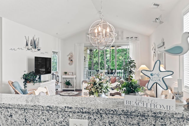 living room with lofted ceiling, plenty of natural light, and a notable chandelier