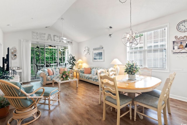 dining space with lofted ceiling, wood-type flooring, and ceiling fan with notable chandelier