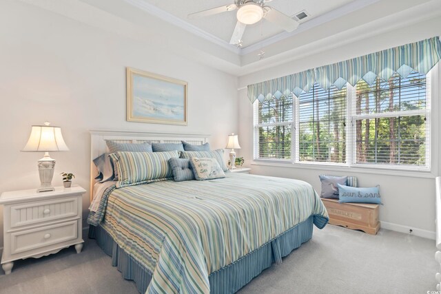 carpeted bedroom featuring a tray ceiling, ceiling fan, and ornamental molding