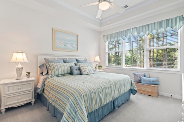 carpeted bedroom featuring crown molding, a raised ceiling, and ceiling fan