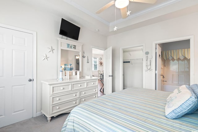 carpeted bedroom featuring connected bathroom, ornamental molding, a closet, and ceiling fan