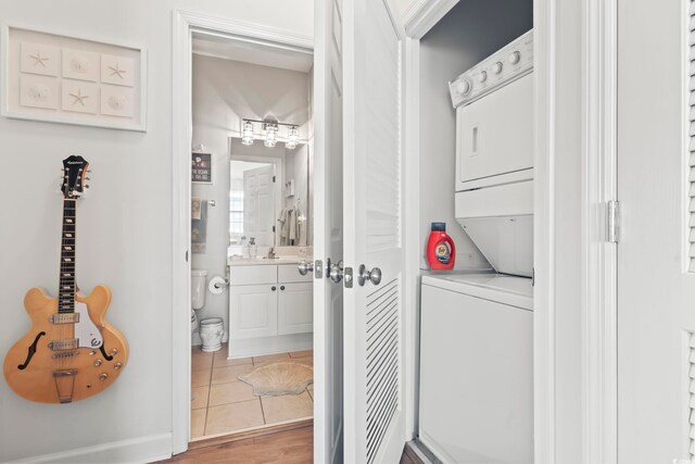 laundry area with tile patterned floors and stacked washer / drying machine