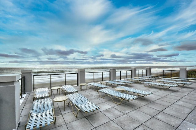 view of patio with a balcony and a water view