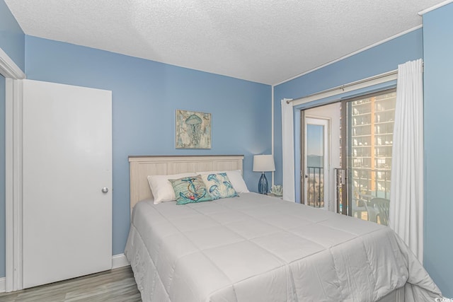 bedroom with a textured ceiling and light wood-type flooring