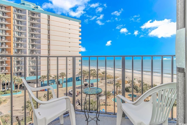 balcony with a water view and a view of the beach