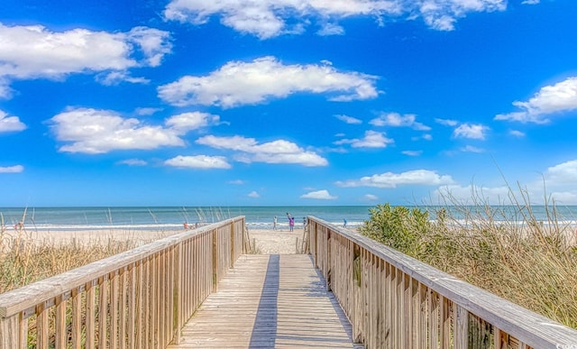 view of property's community with a water view and a view of the beach